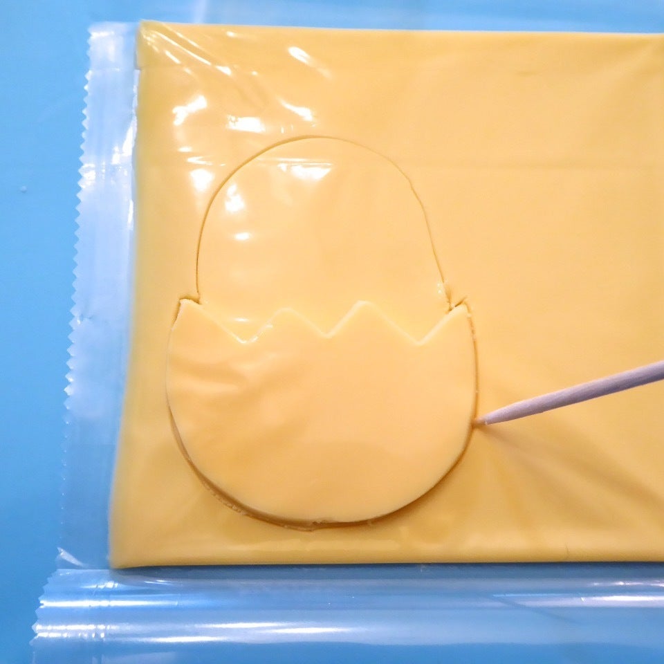 それをもう一枚のチェダーチーズに乗せて、今度はぐでたまの上半身も一緒に切り取ります。