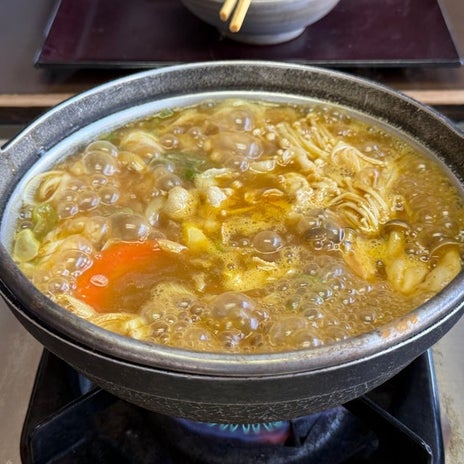 ぐっつぐつに煮込まれたうどん鍋の画像