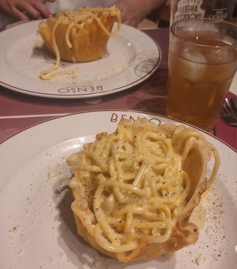 チーズの器に盛られた濃厚パスタの画像