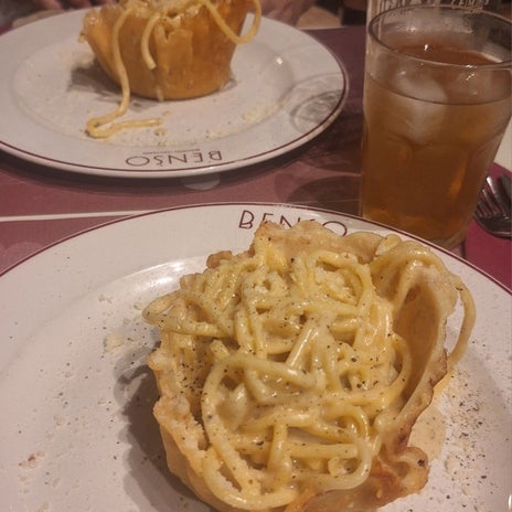 チーズの器に盛られた濃厚パスタの画像