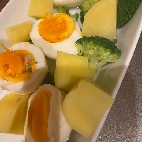カレーを半皿と食べたゆで卵サラダの画像